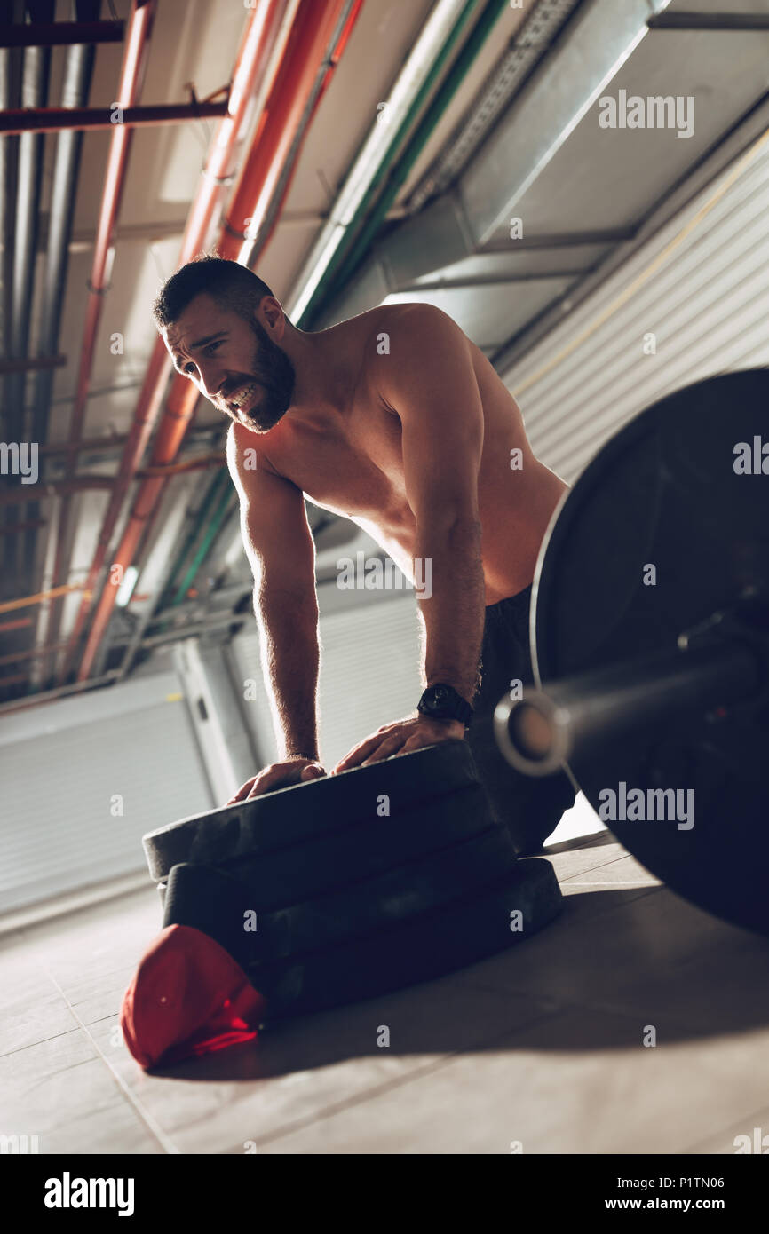 Junge Erschöpfung muskulösen Mann Ausruhen nach schweren hartes Training in der garage Gym. Stockfoto