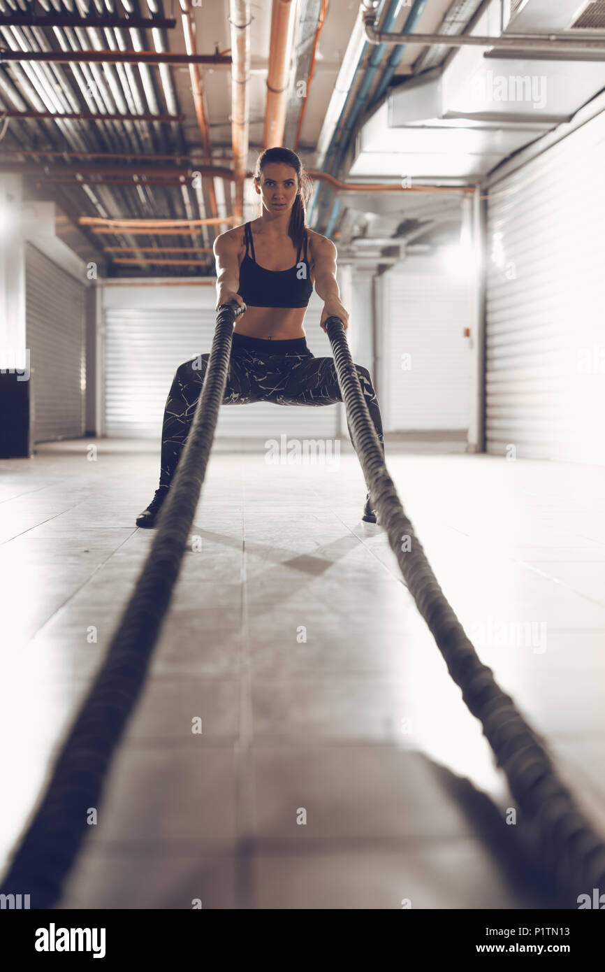 Muskulöse junge Frau, die mit Seilen an der Garage Gym. Selektive konzentrieren. Stockfoto