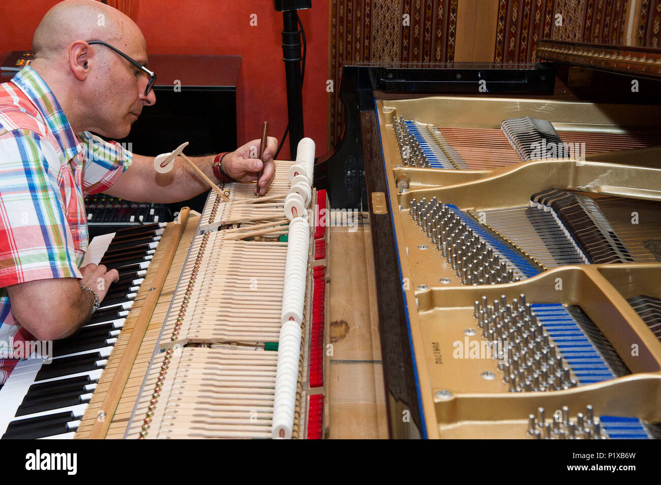 Europa, Italien, Lombardei Mailand. Piano Tuner Techniker während einer Reparatur eines Hammers. Stockfoto