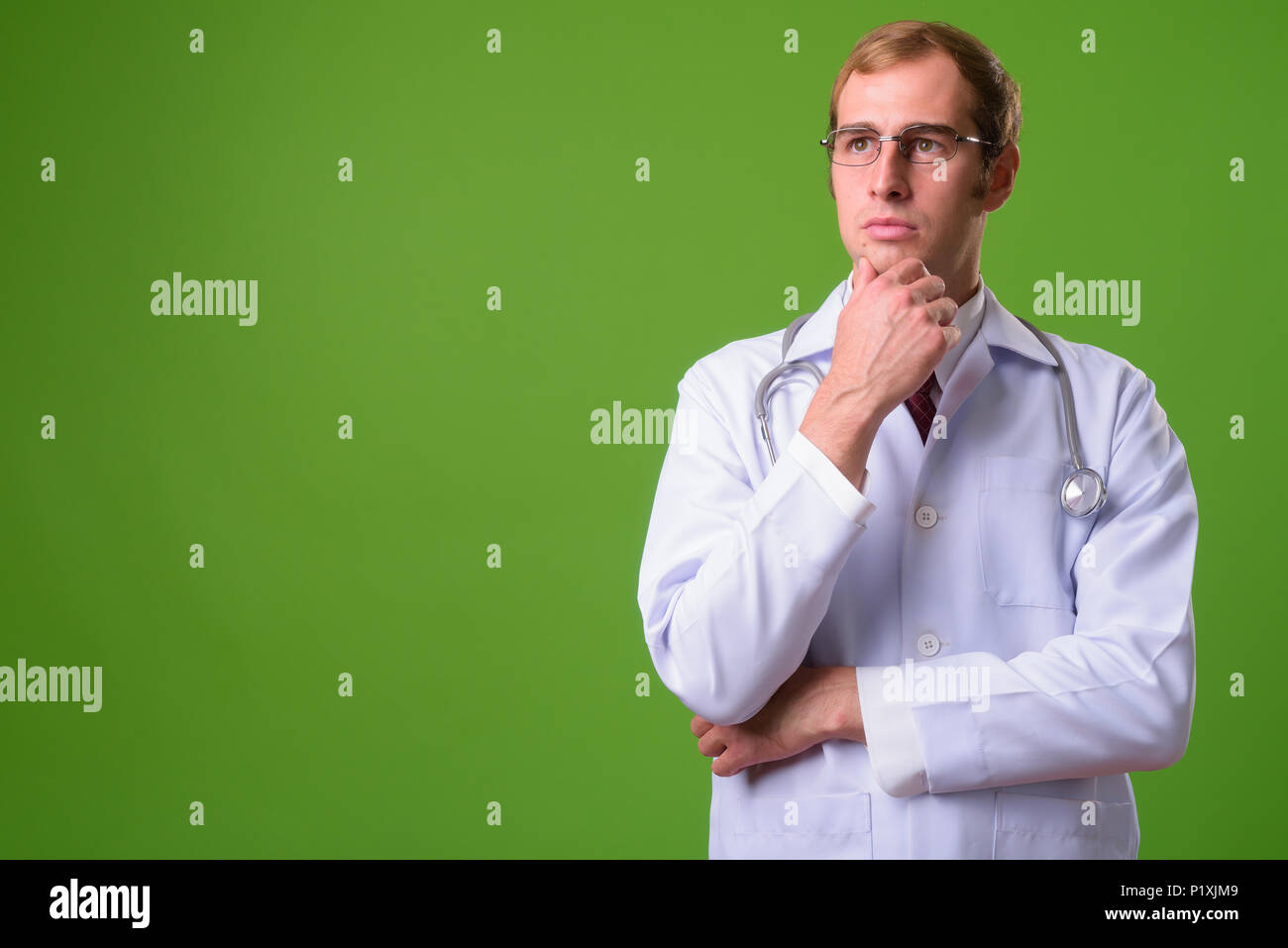 Junger Mann Arzt gegen grüner Hintergrund Stockfoto