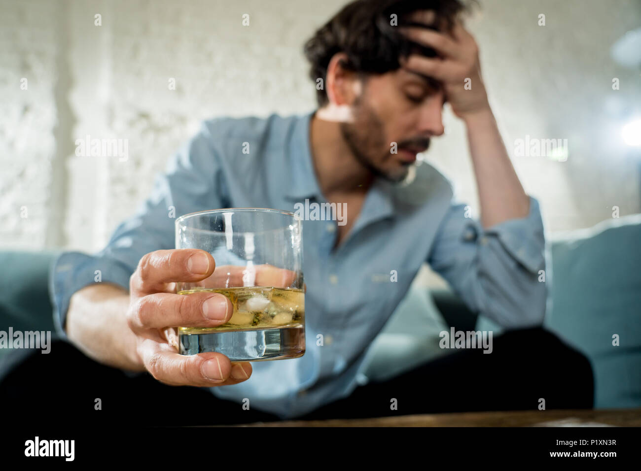 Betrunkene alkoholischen Lain business Mann trinken Whisky aus der Flasche und Glas gedrückt verschwendet und zu Hause couch in Alkoholmissbrauch und Alkoholismus co traurig Stockfoto