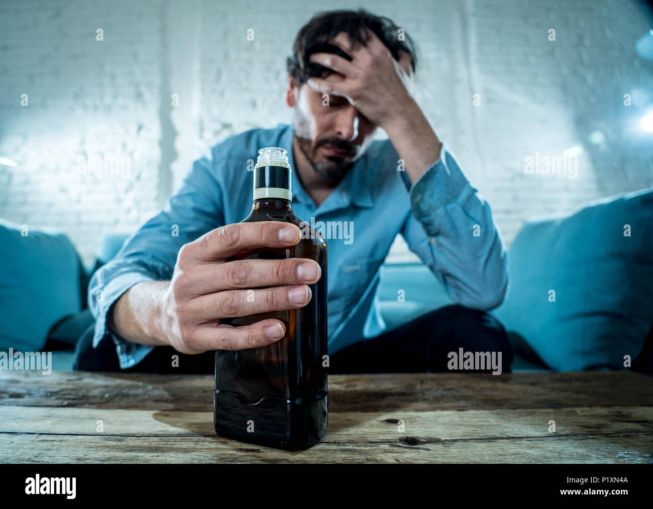 Betrunkene alkoholischen Lain business Mann trinken Whisky aus der Flasche und Glas gedrückt verschwendet und zu Hause couch in Alkoholmissbrauch und Alkoholismus co traurig Stockfoto