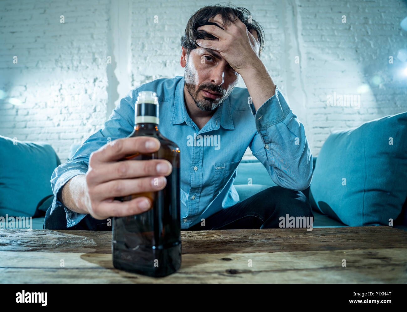 Betrunkene alkoholischen Lain business Mann trinken Whisky aus der Flasche und Glas gedrückt verschwendet und zu Hause couch in Alkoholmissbrauch und Alkoholismus co traurig Stockfoto