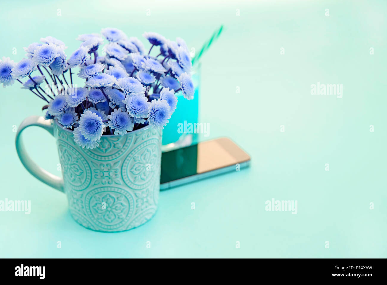 Surrealismus Blumenstrauß aus Chrysanthemen Die Zustellung der Blumen in einer Tasse Tee Glas cocktail Telefon. Festival grüner Hintergrund Stockfoto