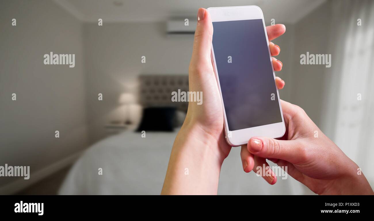 Telefon in der Hand im Schlafzimmer Stockfoto