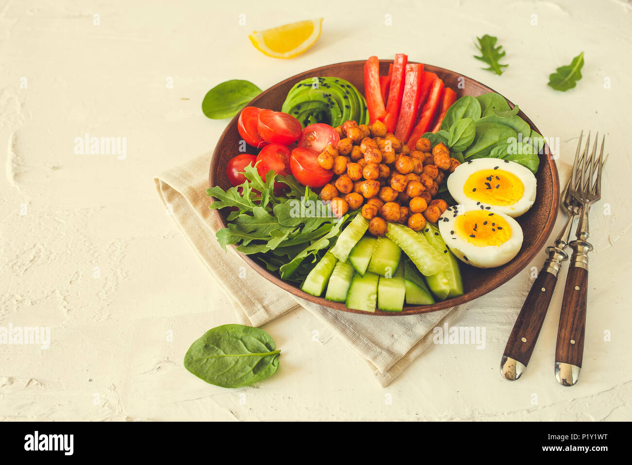 Buddha Schüssel, gesunde und ausgewogene Ernährung. Frittierte Kichererbsen, Tomaten, Gurken, Paprika, Eier, Spinat, Rucola. Stockfoto