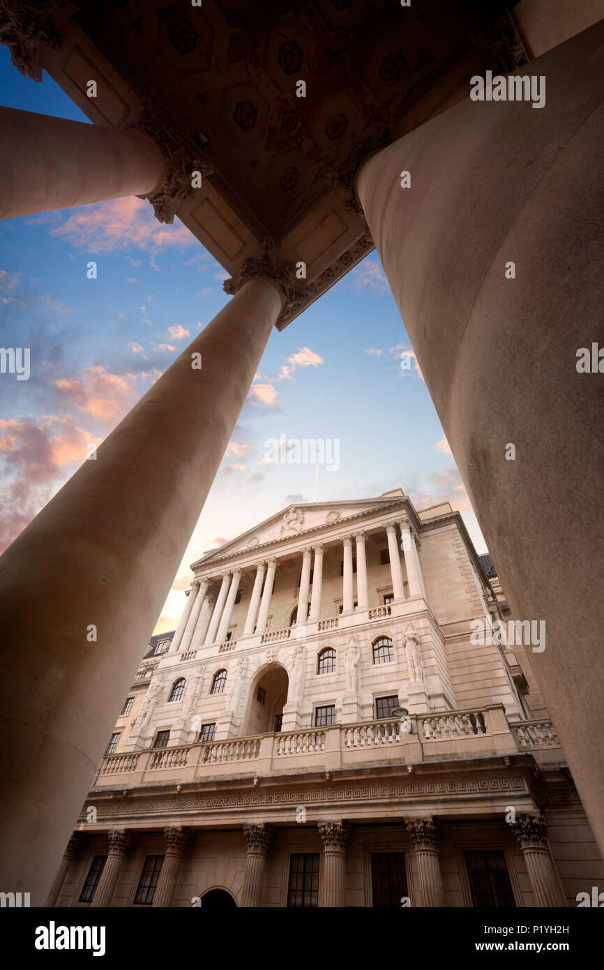 Die Bank von England Hauptsitzt auf Threadneedle Street in der City von London, England, gesehen durch die Spalten der Royal Exchange bei Sonnenuntergang Stockfoto