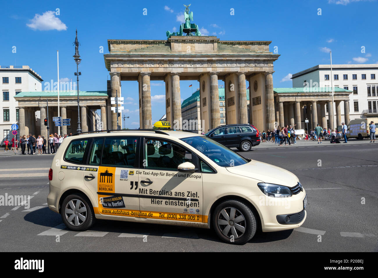 BERLIN, DEUTSCHLAND - 28. APRIL 2018: Deutscher Taxi fahren vorbei am historischen Brandenburger Tor. Stockfoto