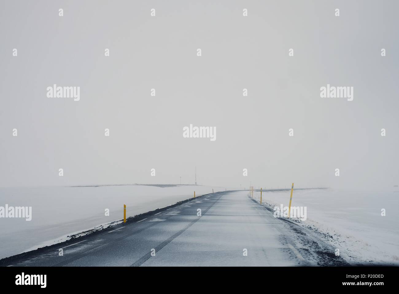 Straße verschwindet in weißen Nebel und Schnee Stockfoto
