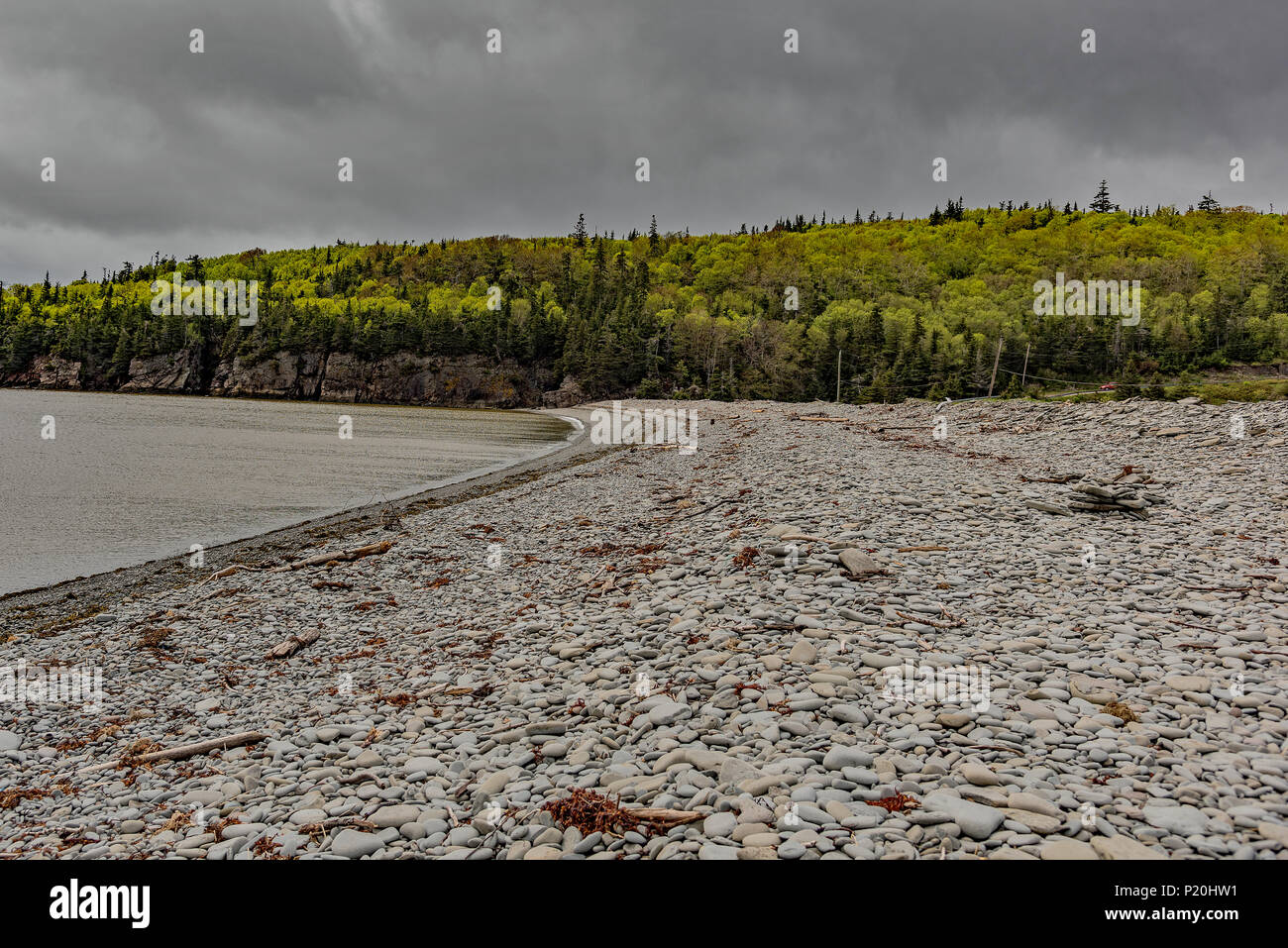 Steiniger Strand. Glatte, runde Steine und eine inukshuk an einem einsamen Strand am Kap Wutanfall, New Brunswick, Kanada. Stockfoto