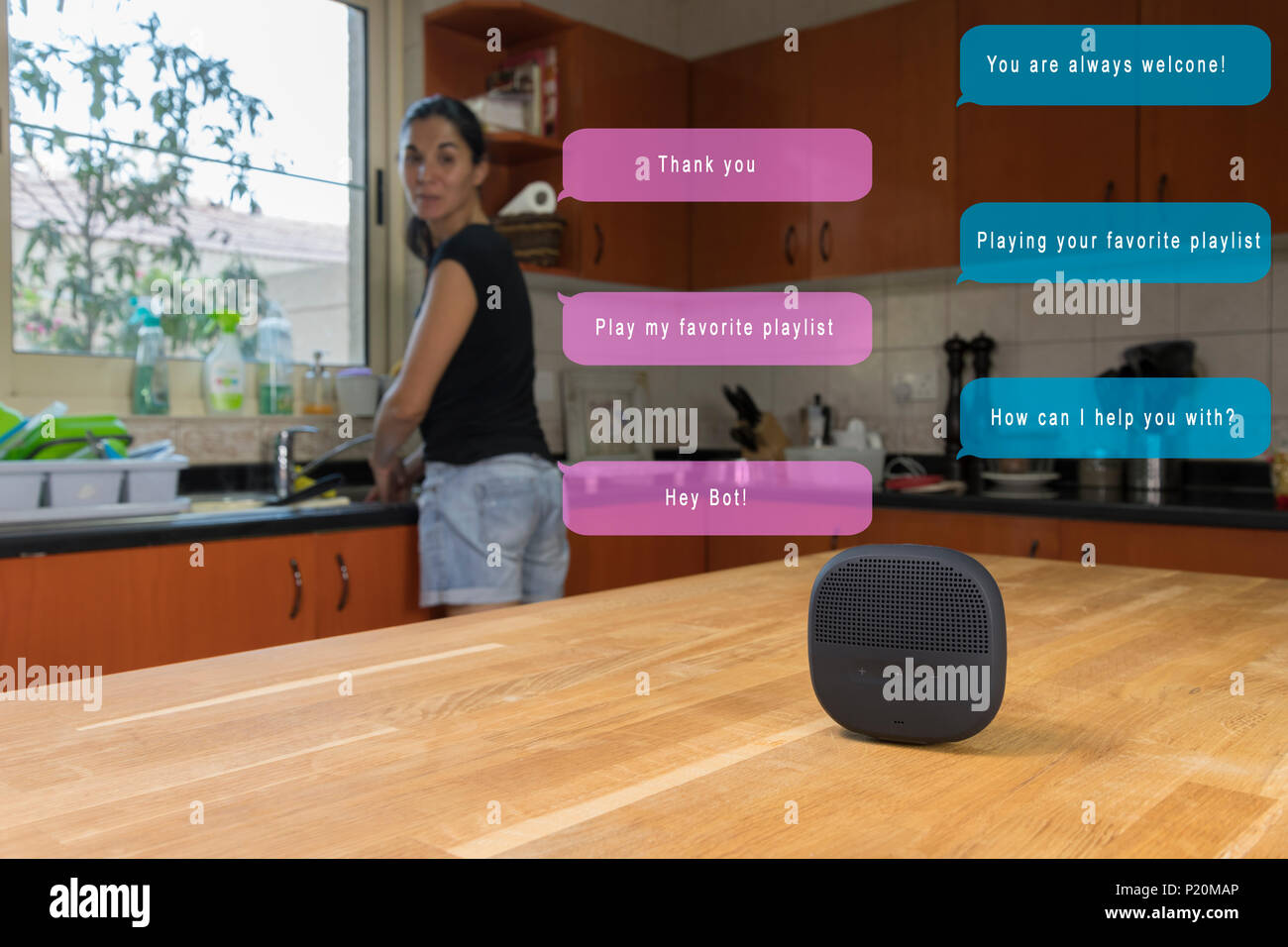 Frau in ihrer Küche und Sie bitten, smart Lautsprecher Ihrer bevorzugten Wiedergabeliste abspielen Stockfoto