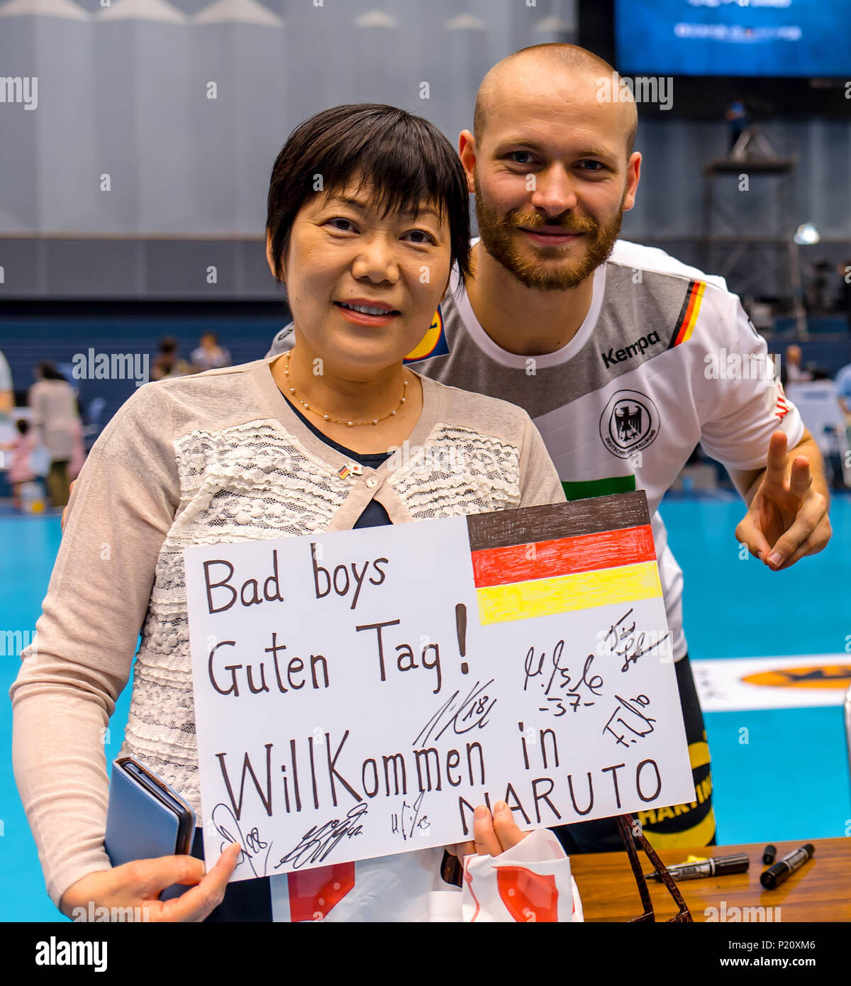 13 Juni 2018, Tokushima, Japan - internationales Freundschaftsspiel, Japan gegen Deutschland: Beide Teams geben Autogramme frei nach dem Match. Moritz Preuss stellt mit einem Japanischen fan Holding das Zeichen "Bad Boys Guten Tag! Welcome in Naruto" (Lit. "Hallo Bad Boys! Willkommen bei Naruto"). Foto: Sascha Klahn/dpa Stockfoto