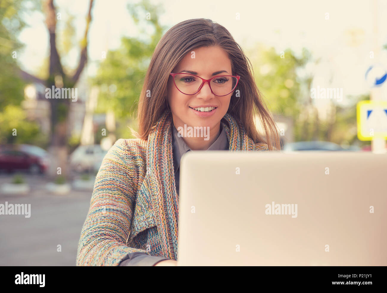 Attraktive junge Frau mit Laptop außerhalb Stockfoto