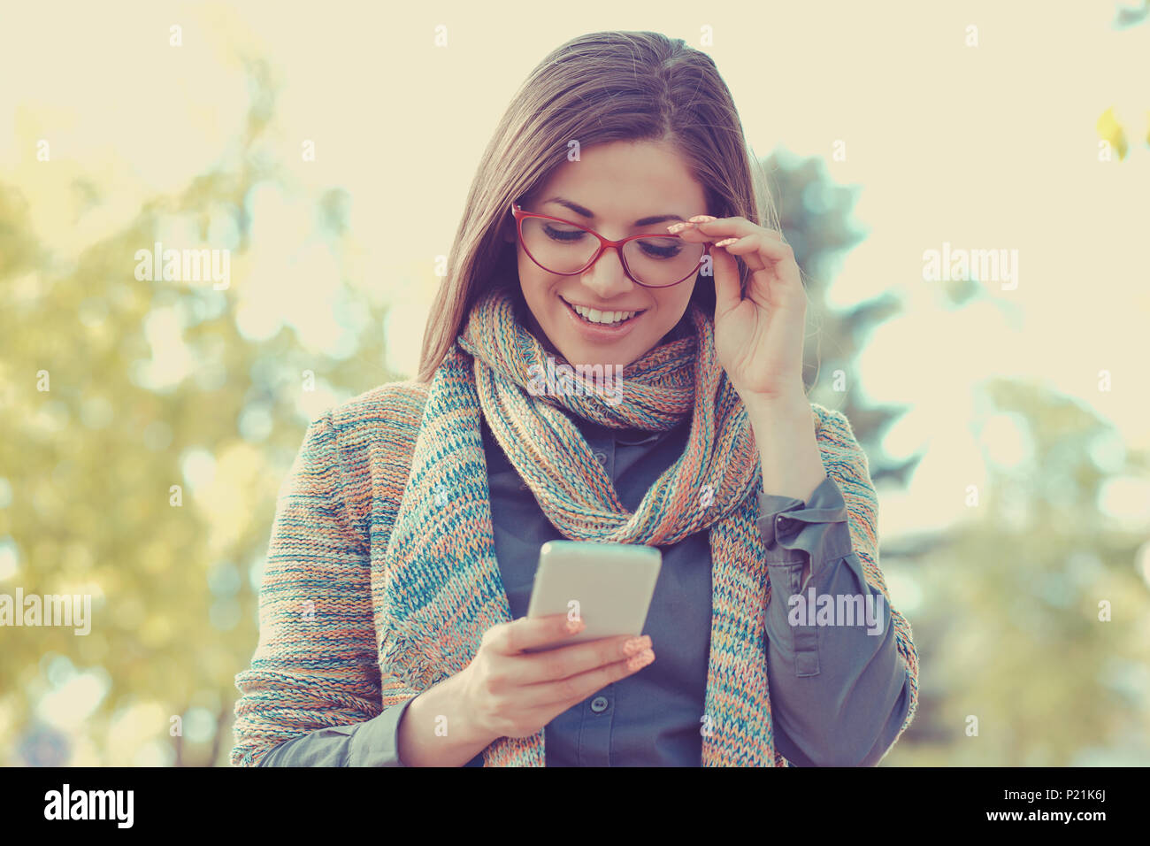 Junge Frau wandern und SMS-Nachrichten auf dem Smartphone in der Straße auf einem Sommer sonnigen Tag Stockfoto