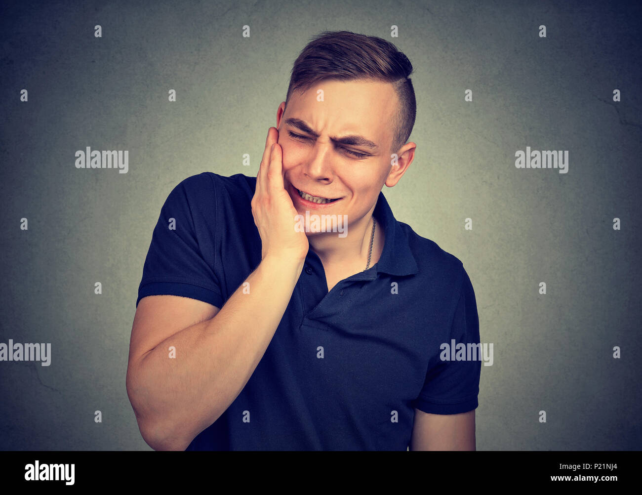 Zahnschmerzen. Frustriert junger Mann in Schmerz seine Wange berühren und halten die Augen geschlossen Stockfoto