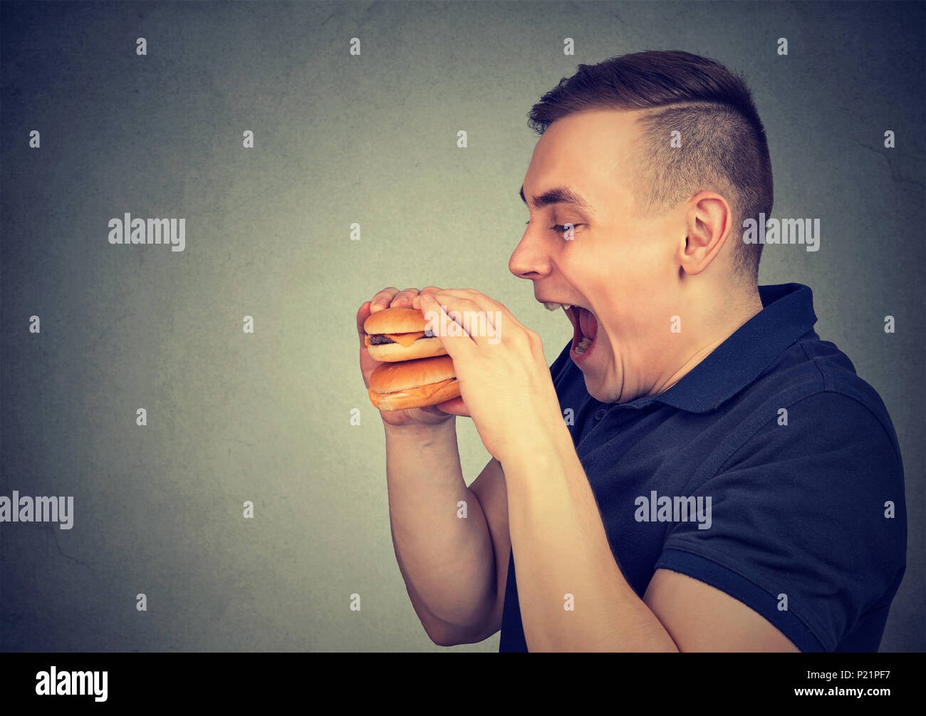 Mann Essen der Trödelnahrung doppelten Cheeseburger Stockfoto