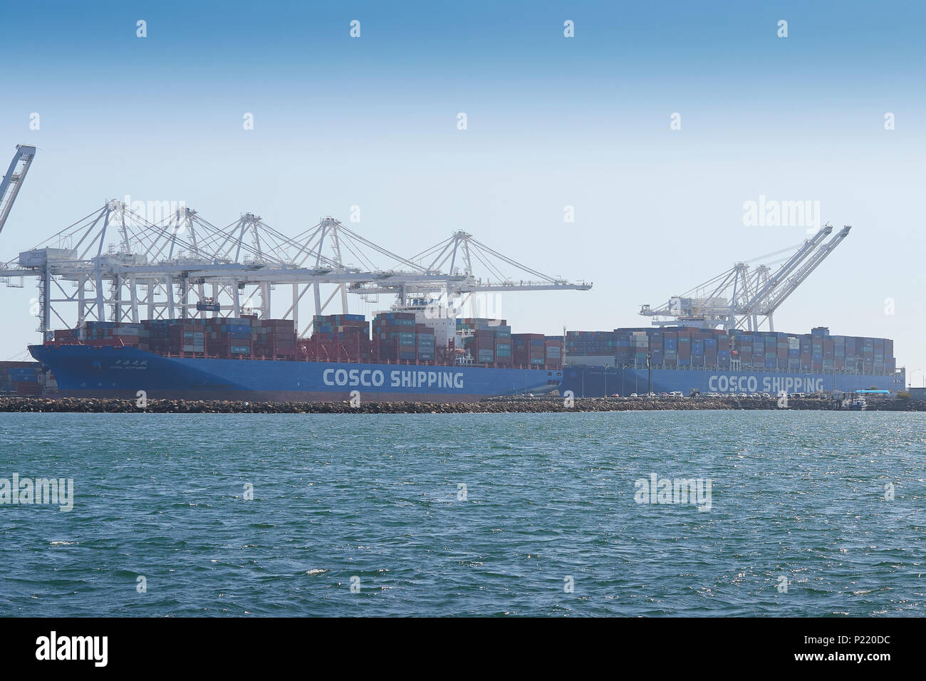 Zwei COSCO-VERSCHIFFUNGEN, Containerschiffe, die im Long Beach Container Terminal, Kalifornien, USA, geladen und entladen werden. Stockfoto