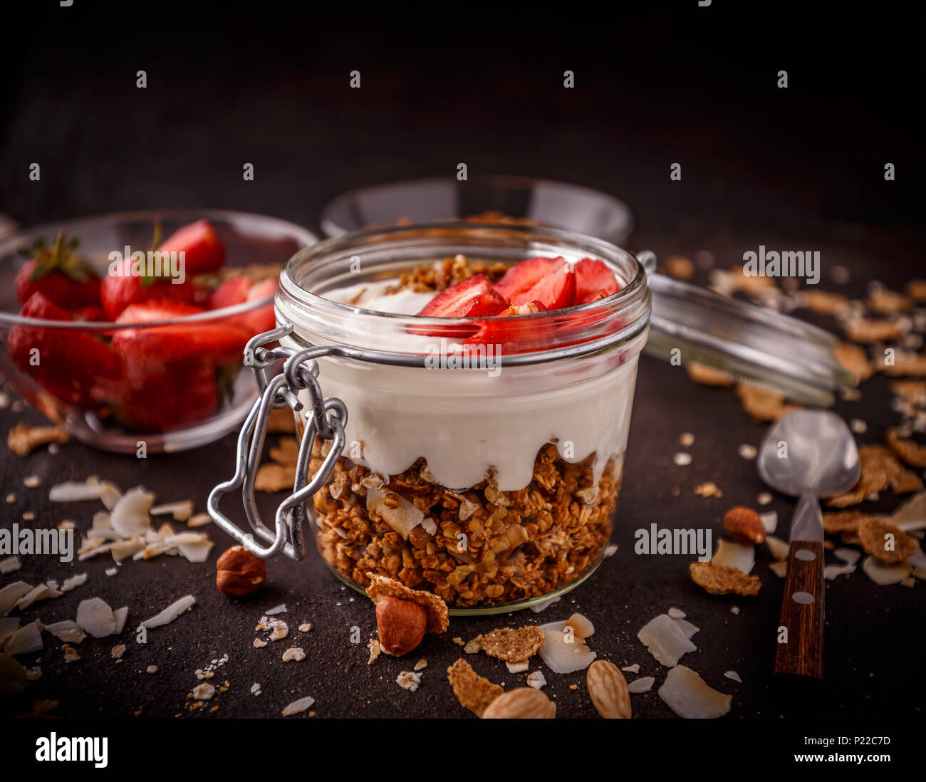 Hausgemachtes Müsli mit Joghurt und Erdbeeren im offenen Glas Glas Stockfoto