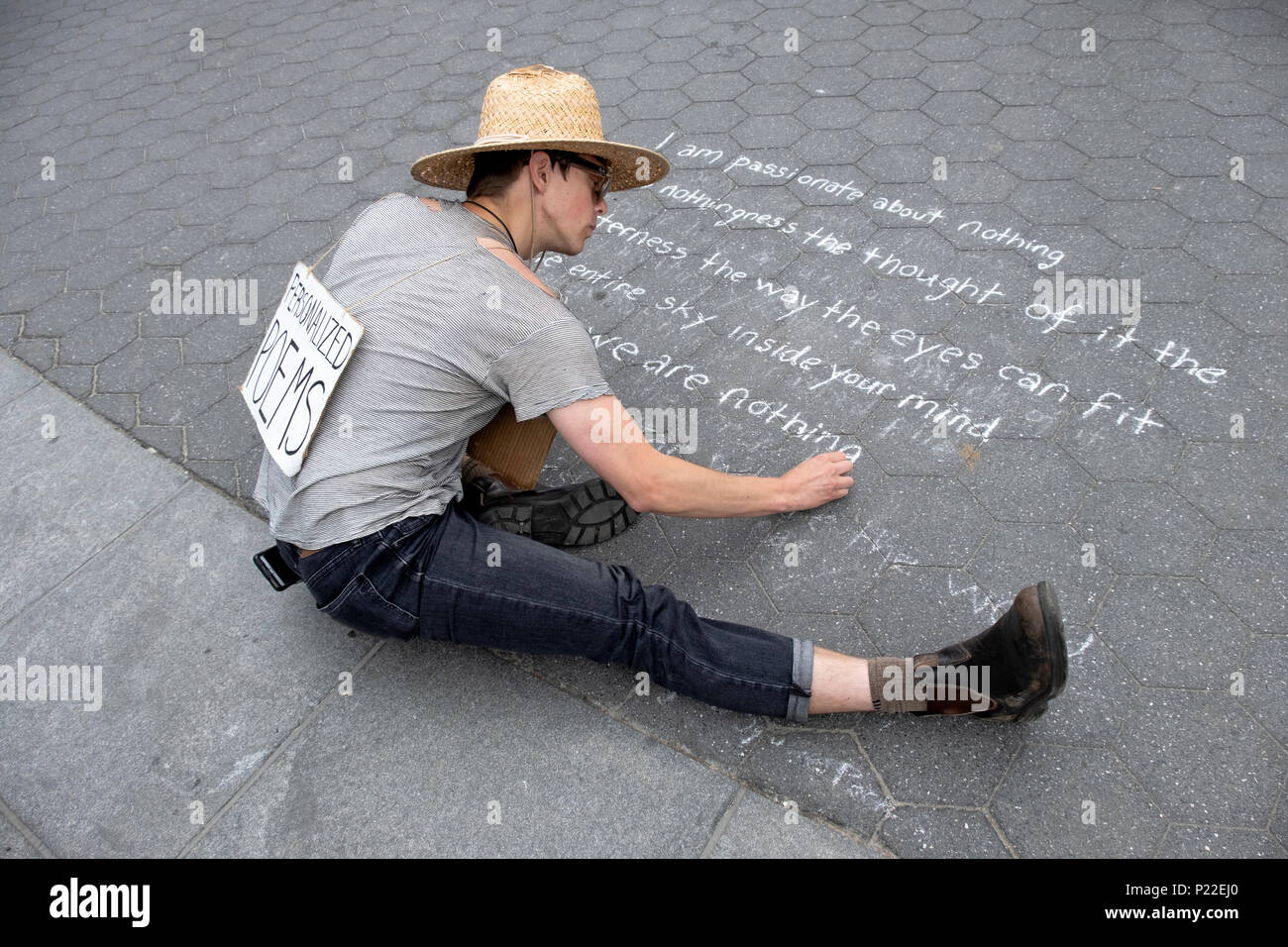 Ein Mann, der schreibt personalisierte Gedichte schreiben ein Gedicht mit Kreide auf dem Boden im Washington Square Park in Manhattan, New York City. Stockfoto