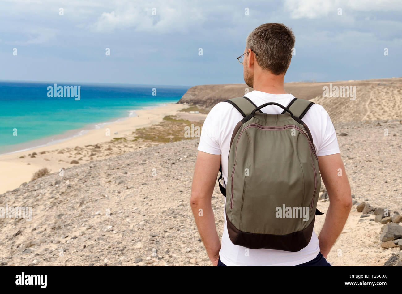 Ein Tourist mit einem Rucksack bewundern Sie die Aussicht auf das Meer Strand von Sotavento Stockfoto