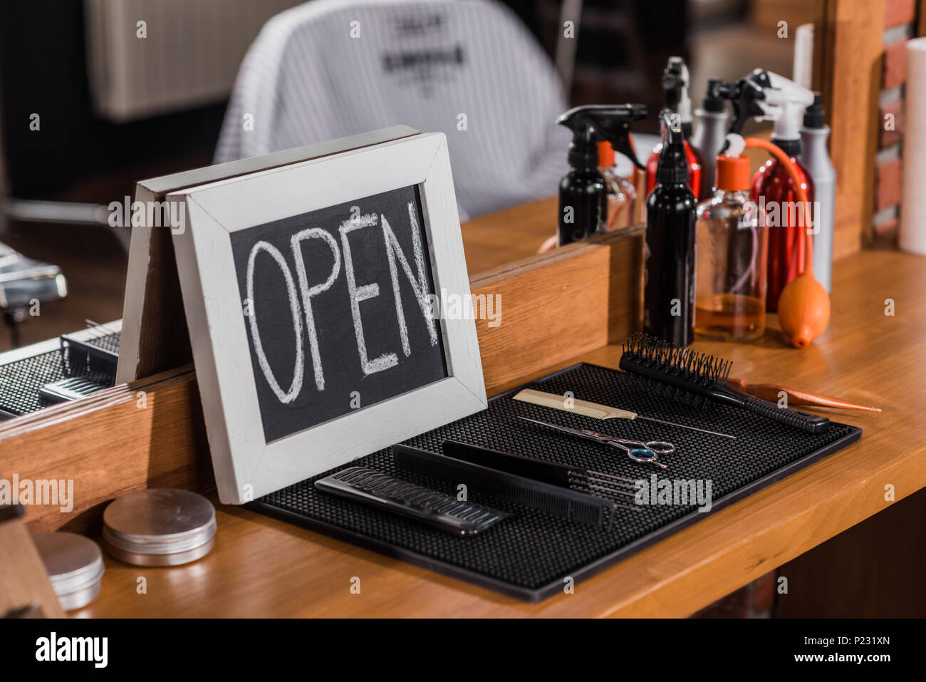 Nahaufnahme der Tafel mit offenen Zeichen lehnte sich auf Spiegel an Barbershop Stockfoto