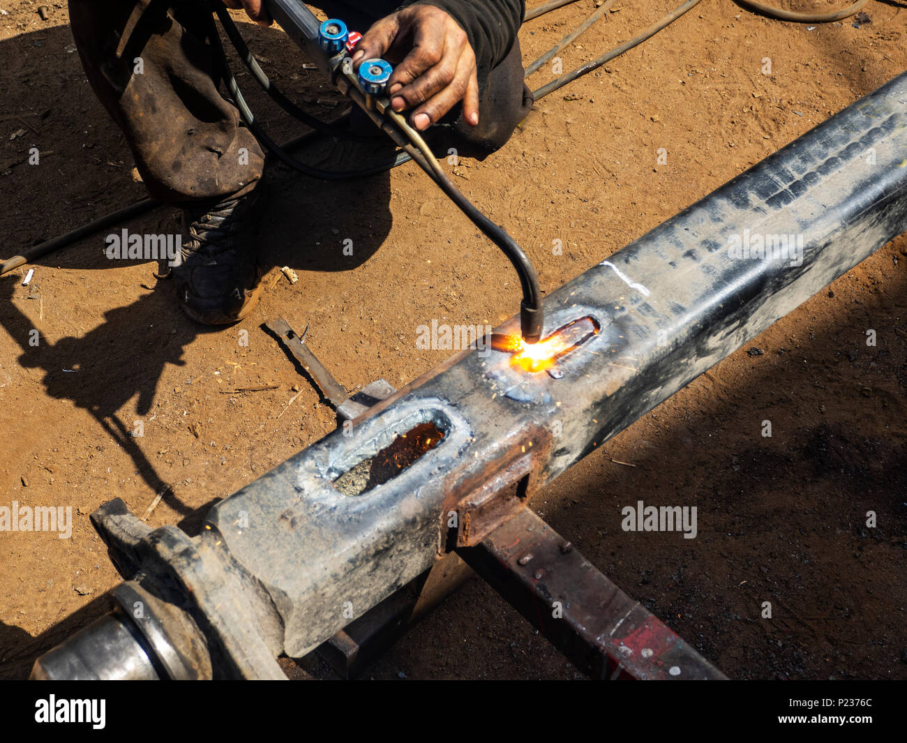 Metall arbeiten. Man schneidet ein Loch in einen Stahl Stück mit gas schweißen Stockfoto