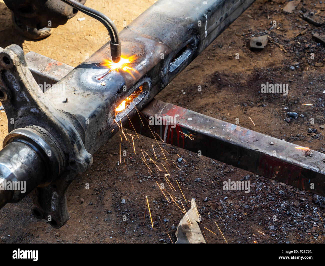 Metall arbeiten. Man schneidet ein Loch in einen Stahl Stück mit gas schweißen Stockfoto