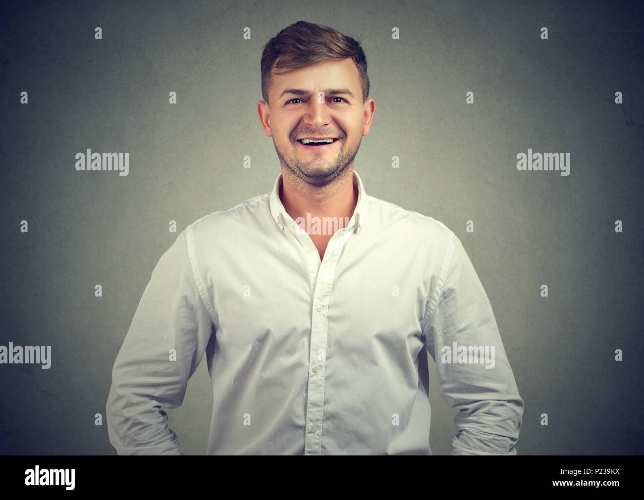 Casual junger Mann im Hemd auf Kamera mit positiven Emotionen und Lachen sorglos. Stockfoto