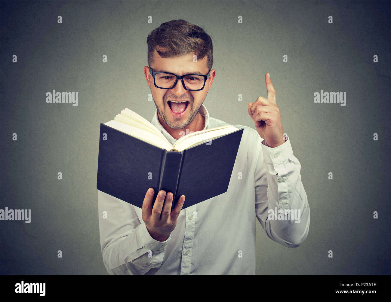 Mann in Gläser aufschlussreiche Erkenntnisse beim Lesen smart Buch finger Holding in Aufregung. Stockfoto