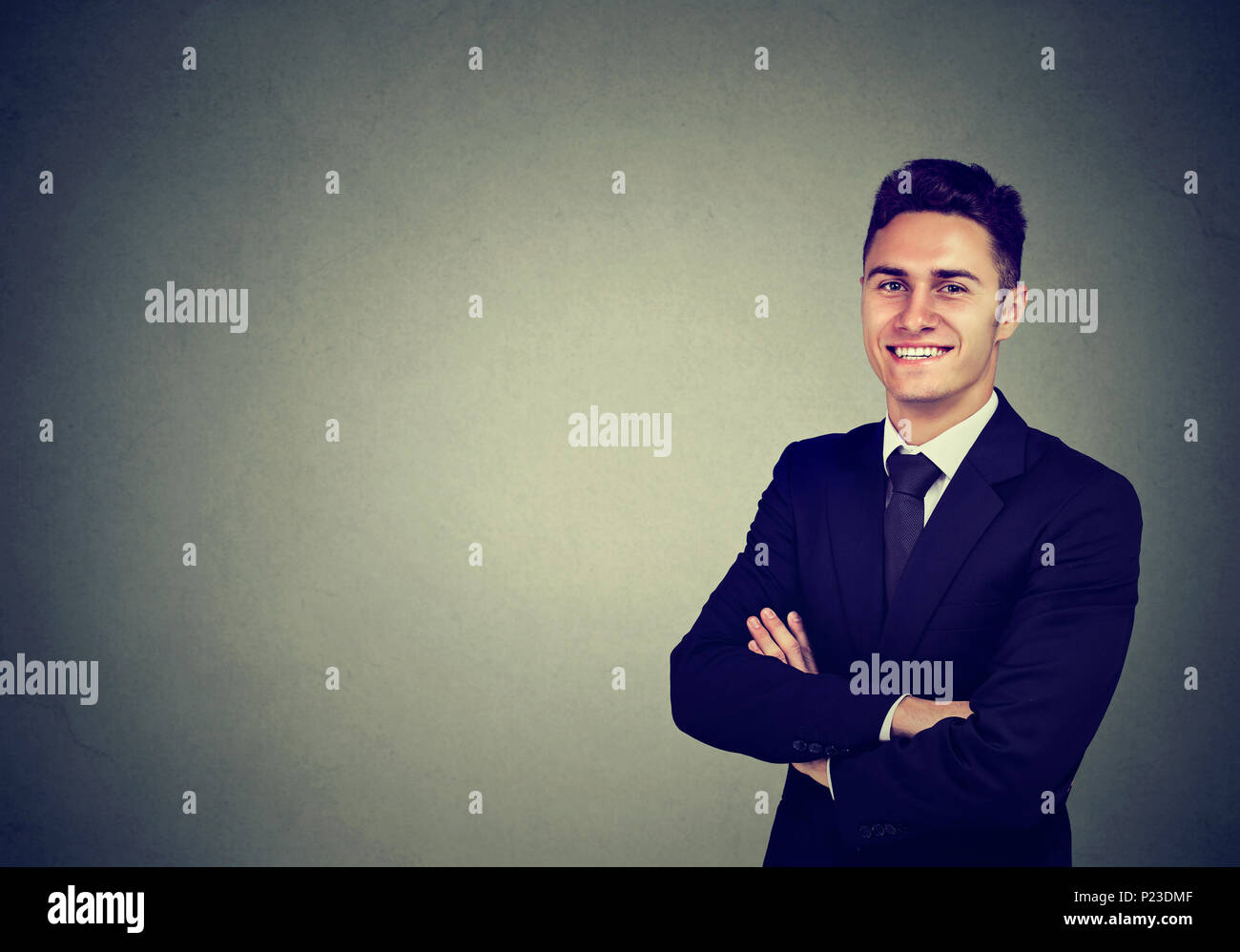 Portrait von zuversichtlich heiter Geschäftsmann auf grauem Hintergrund Stockfoto