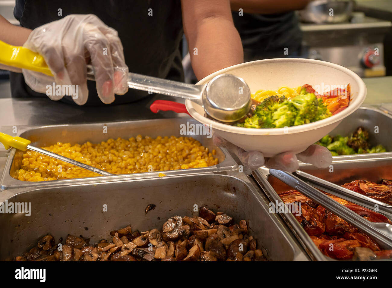 Ein Arbeiter bereitet einen Salat zum Mittagessen in einem Fast Food Restaurant in Midtown Manhattan in New York am Donnerstag, 7. Juni 2018. (© Richard B. Levine) Stockfoto