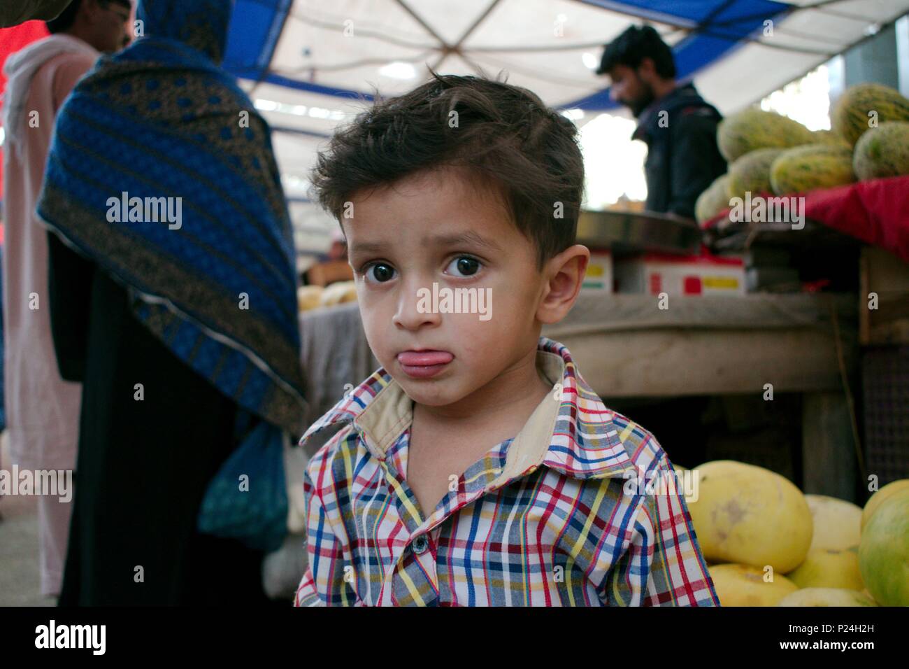Beautiful kid (Kind) mit seine Zunge heraus und großen Augen in Islamabad, Pakistan Stockfoto