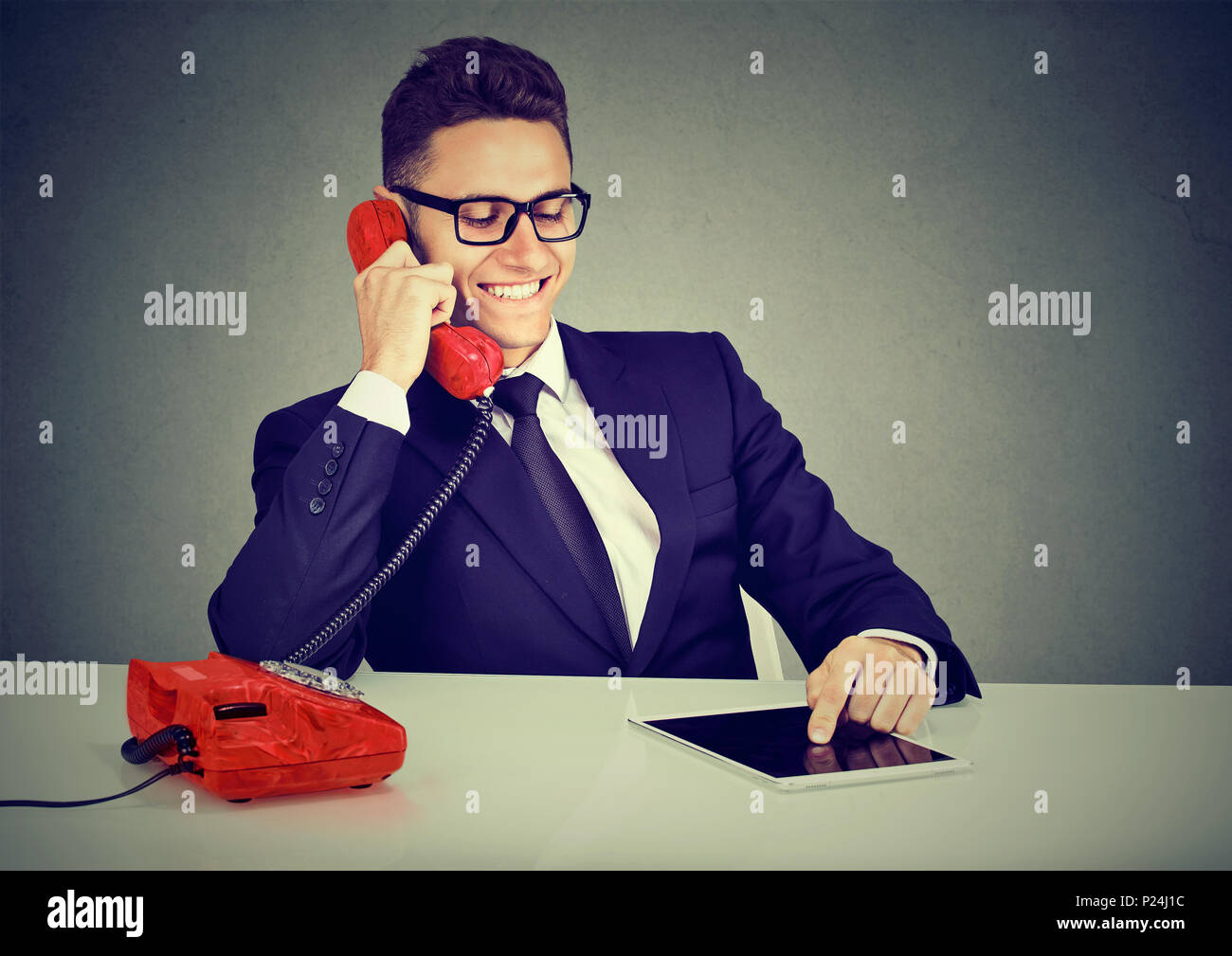 Happy business Mann mit Tablet Computer mit angenehmen Gespräch am Telefon Stockfoto