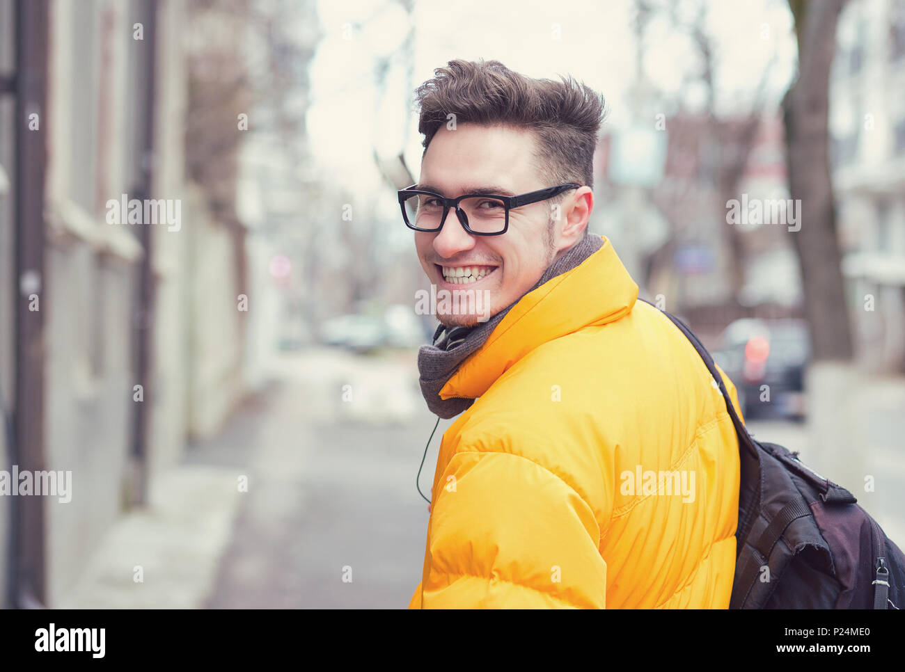 Junge stilvollen Mann in Oberbekleidung und Brillen über die Schulter schauen auf die Straße. Stockfoto