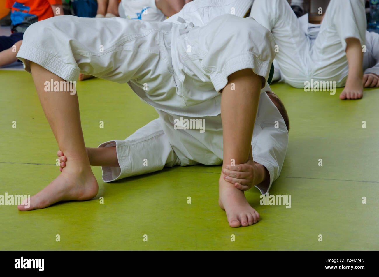 Ein Junge in den Kimono üben Karate auf dem Boden in der Turnhalle Stockfoto