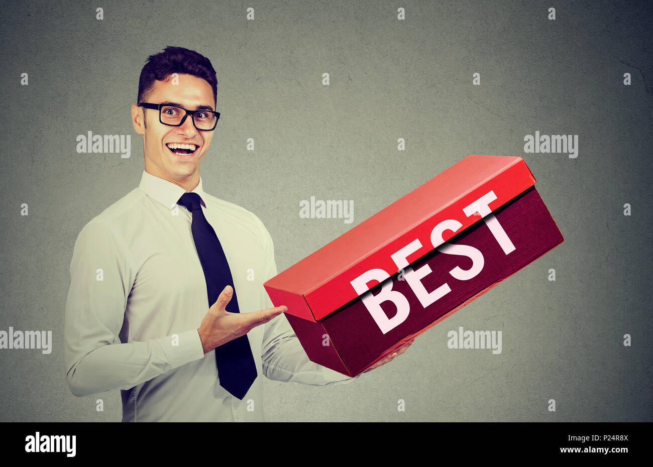Lächelnd Verkäufer Geschäftsmann Werbung sein bestes Produkt in einem großen roten Kasten Stockfoto