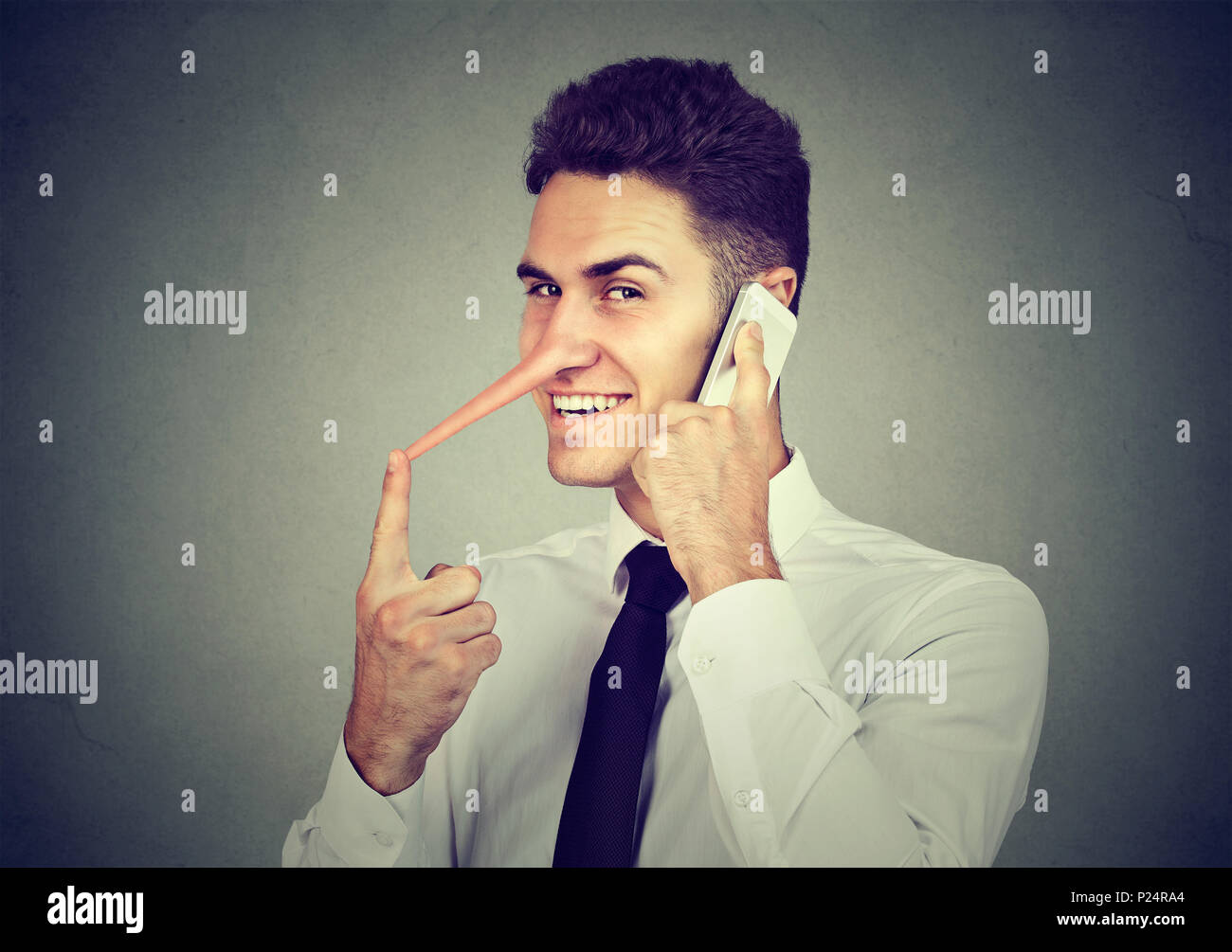 Sly jungen Mann mit langen Nase Gespräch am Handy auf grauen Hintergrund. Lügner Konzept. Menschliche Emotionen Gefühle, Charaktereigenschaften Stockfoto