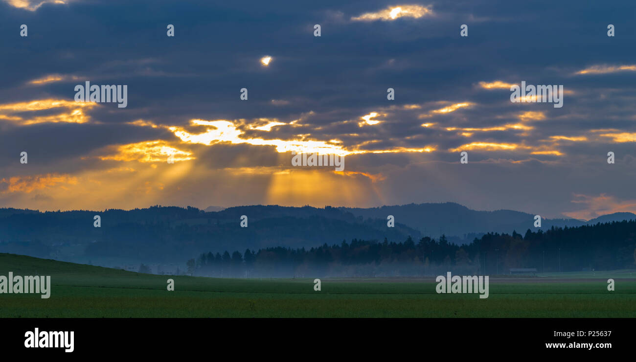 Sonnenstrahlen brechen durch die Wolken im Zürcher Oberland/Zurich Highlands Stockfoto