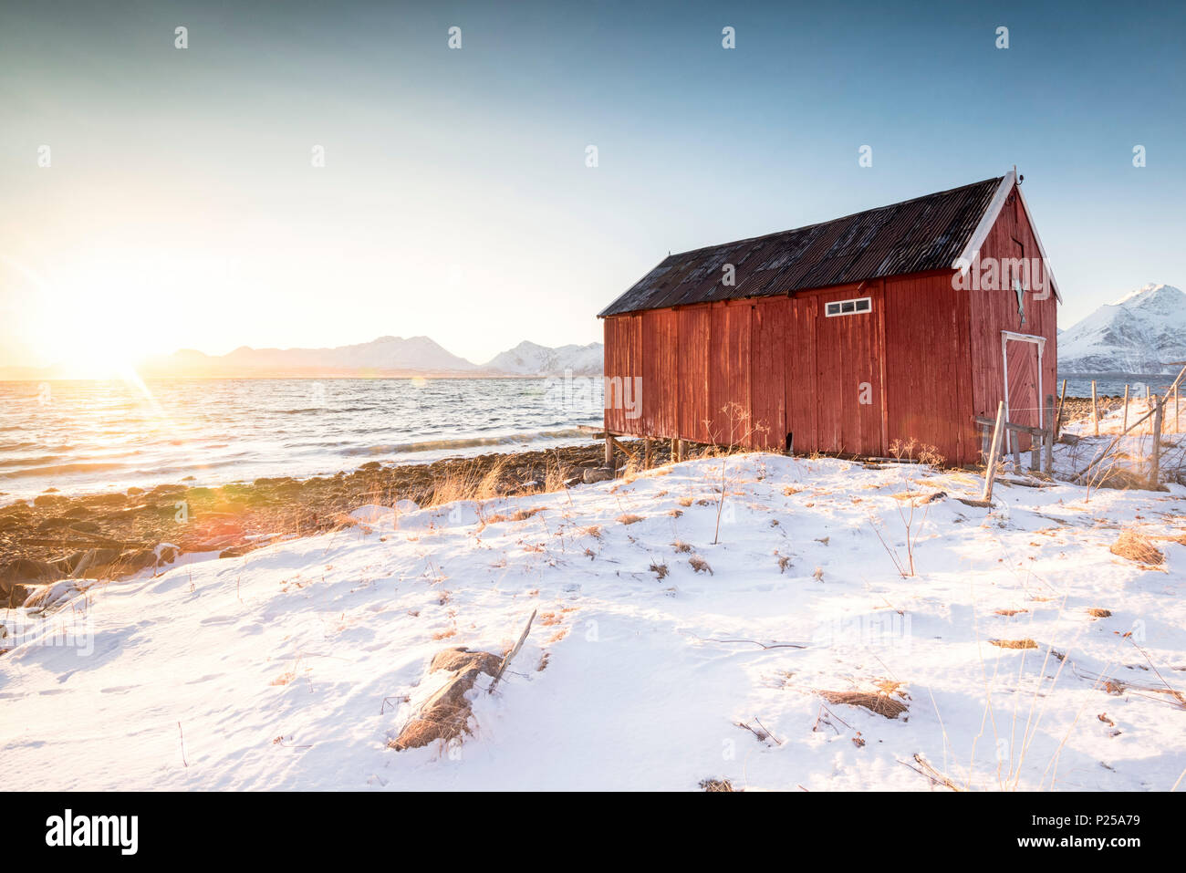 Die typischen roten Haus am Strand im Winter Sonnenuntergang, Nordmannvik, Kafjord, Lyngen Alpen, Tromso, Norwegen, Europa Stockfoto