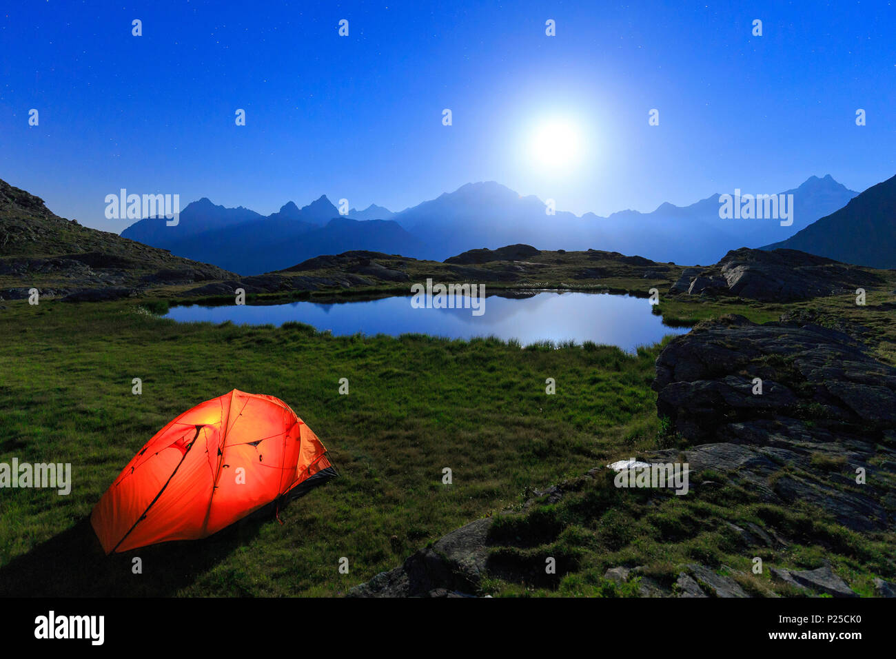 Nacht der Vollmond mit Camping am Ufer eines kleinen Sees. Alpe Foren, Valmalenco, Valtellina, Lombardei, Italien. Stockfoto