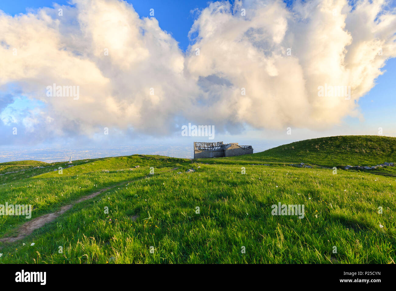 Grosse Wolke über einem zerstörten Haus in einem Park. Monte Linzone, Valico di Valcava Valcava (Pass), Val San Martino, Prealpi Bergamasche, Provinz Bergamo, Lombardei, Italien. Stockfoto