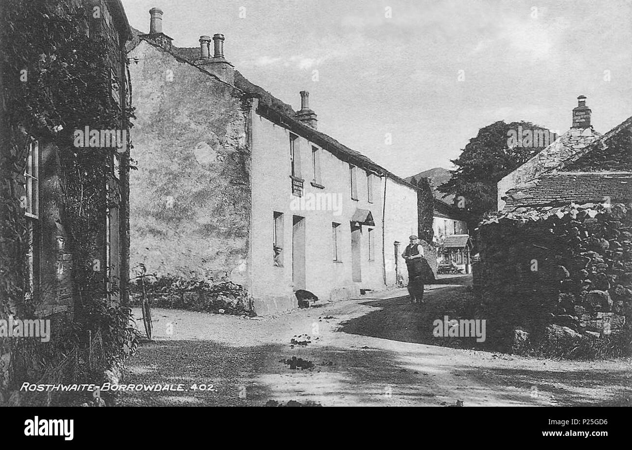 . Englisch: Rosthwaite, im Borrowdale in der Nähe von Keswick, Cumbria, England. Diese Straße durch das Dorf war die B zu werden5289. Die Veranda im Hintergrund ist, dass der heutigen Royal Oak Hotel. Die Glasplatte Fotograf war Henry Mayson, der in Edinburgh geboren wurde und ein Fotostudio es in den 1880er Jahren die Herstellung von Postkarten unter dem "ayson Serie. Seine Arbeit befasste sich die Landschaft und die Menschen des Lake District. Die geog-Lage ist die ungefähre Position der Kamera. Vor 1921. Henry Mayson (1845-1921) Biografie 25 B5289 südlich durch Rosthwaite Borrowdale Cumbria Stockfoto