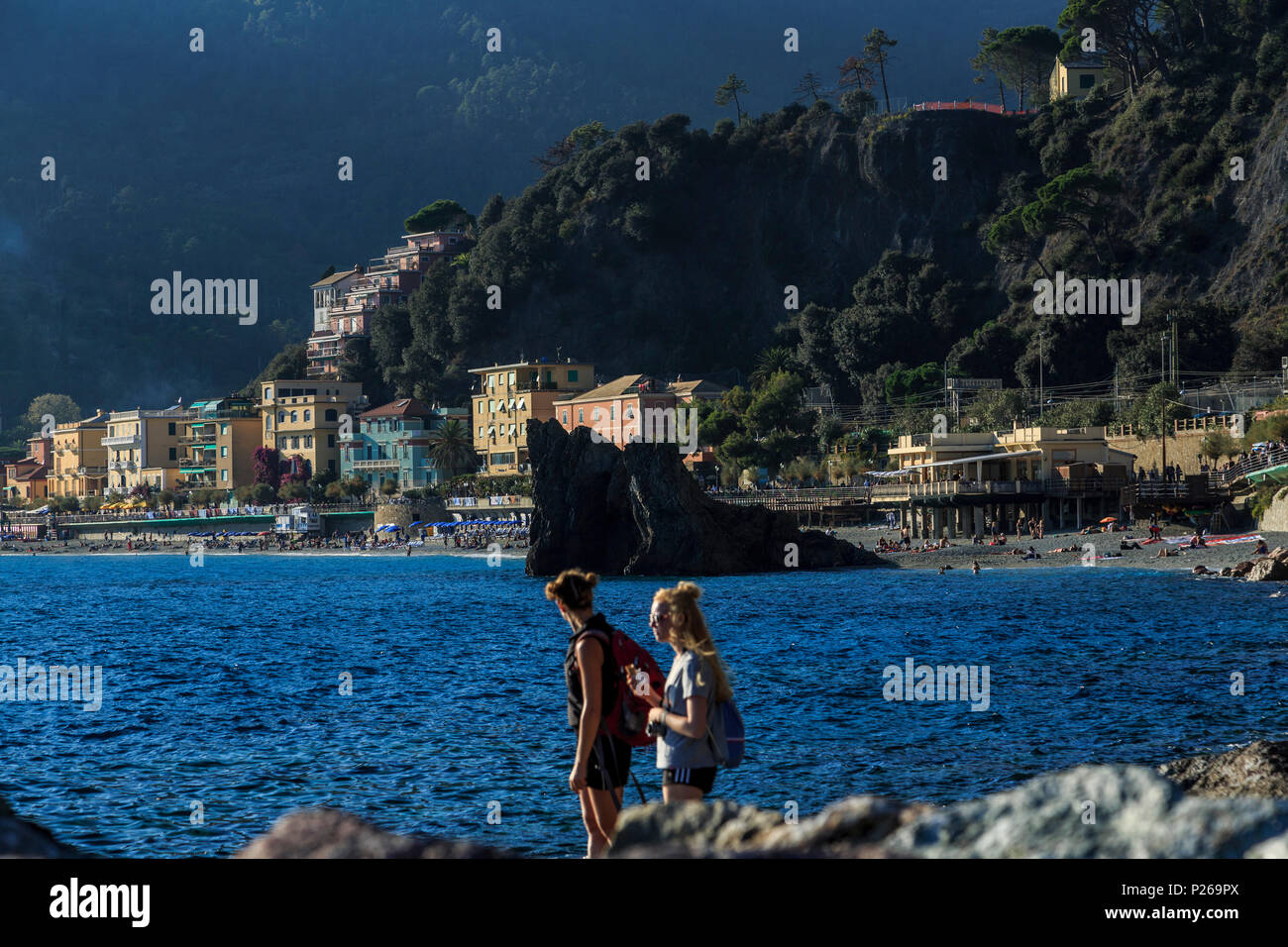 Zwei junge Touristen steht auf Felsen mit Monterosso al Mare hinter Stockfoto