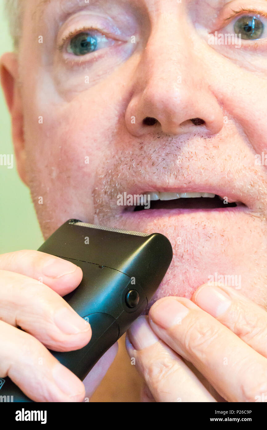 Älterer Mann Rasur mit einem elektrischen Rasierer, USA Stockfoto