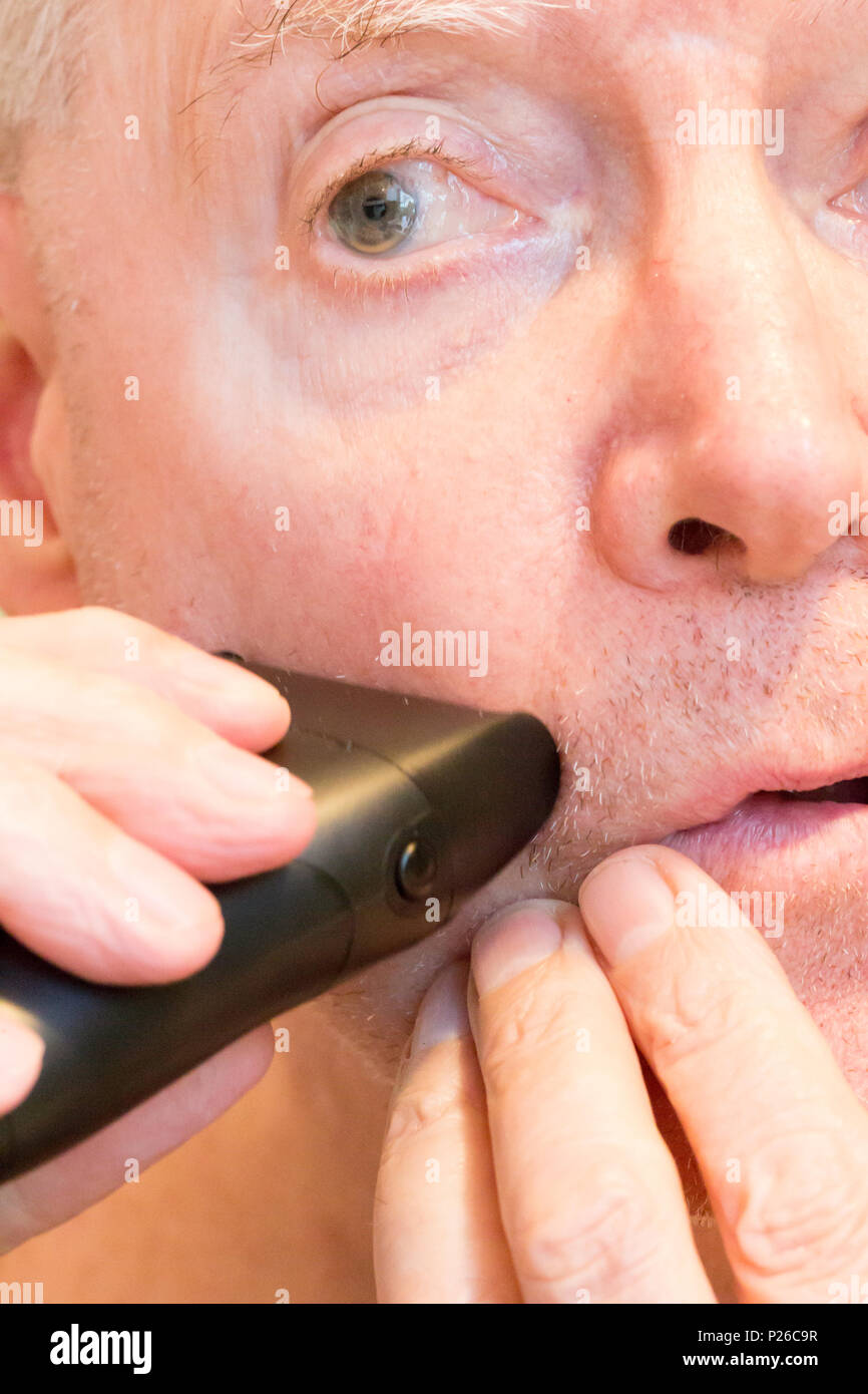 Älterer Mann Rasur mit einem elektrischen Rasierer, USA Stockfoto