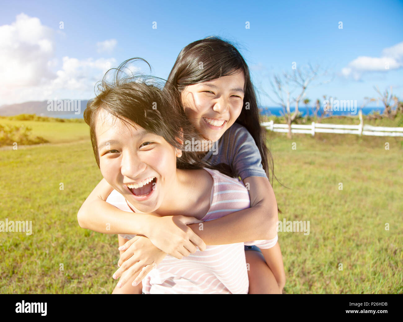 Jugendlicher Mädchen huckepack spielen und Spaß dabei haben Stockfoto