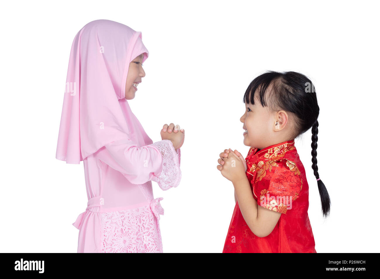 Asiatische Chinesische kleinen Schwestern tragen Cheongsam und traditionellen malaiischen Kostüm mit Gruß Geste in isolierten weißen Hintergrund Stockfoto