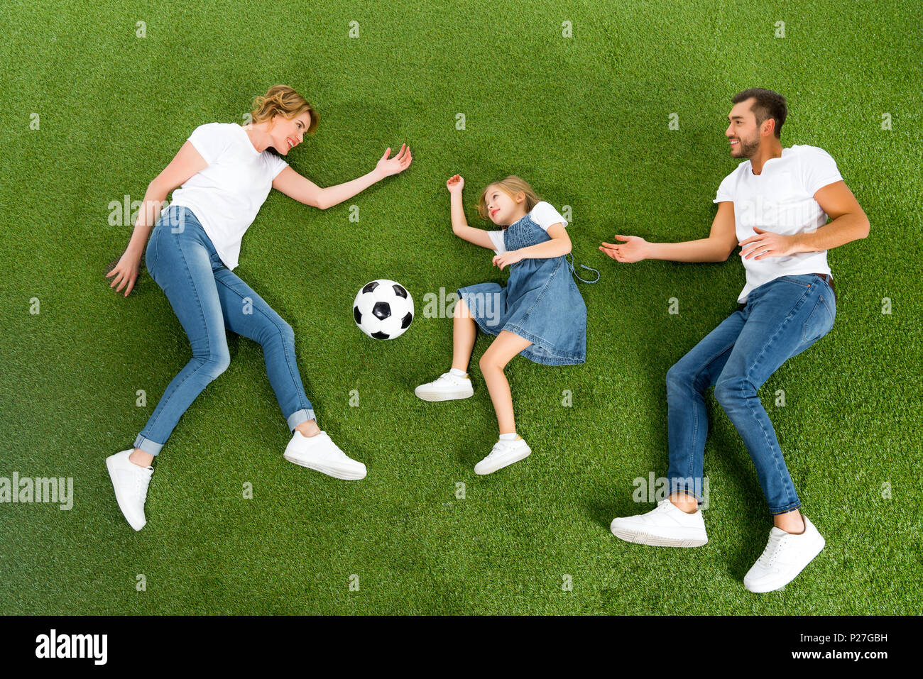 Ansicht von oben der Familie Fußball spielen zusammen auf der grünen Wiese Stockfoto