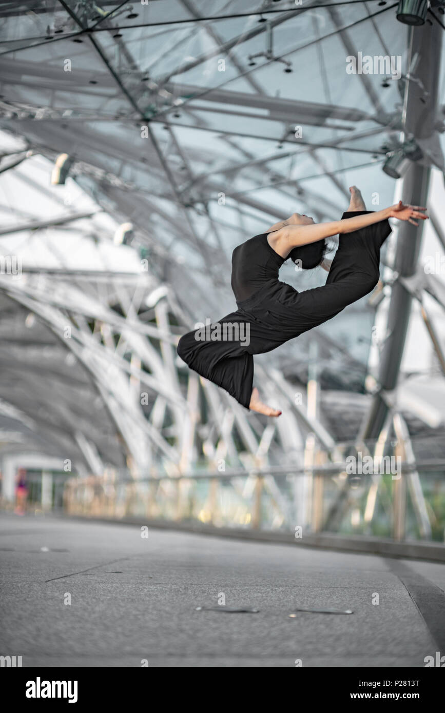 Schöne junge Mädchen tanzen auf einer Brücke, mit schwarzen Stockfoto