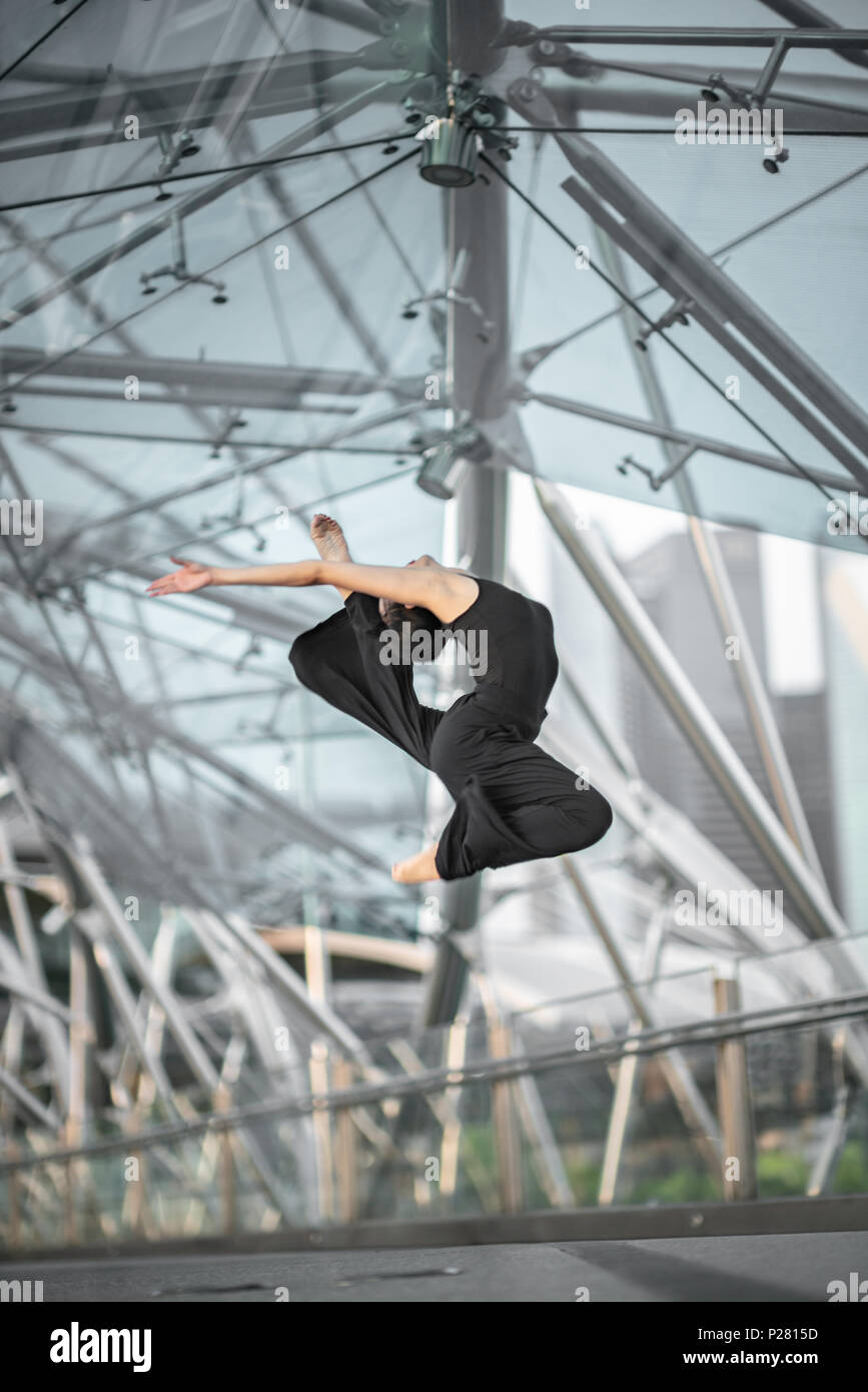 Schöne junge Mädchen tanzen auf einer Brücke, mit schwarzen Stockfoto